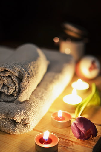 Relaxing Spa Setup with Rolled Towels and Candles