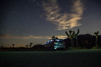 Couple Sleeping on Car Roof Under Starry Night Sky