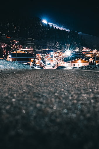 Night view of snowy alpine village with illuminated chalets
