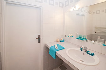 Modern White Bathroom Interior With Turquoise Towels And Sink