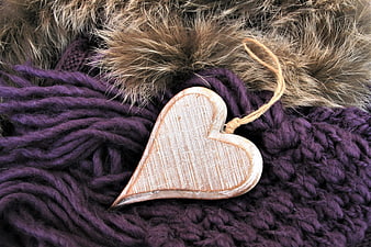 Rustic wooden heart ornament on purple knitted wool and fur