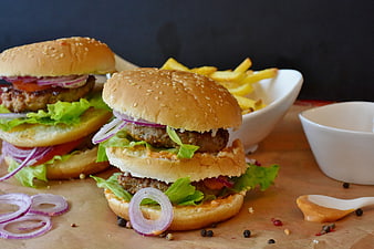 Delicious homemade burgers with fries and sauce on rustic table