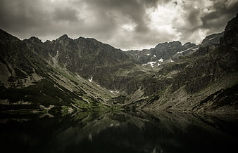 Dramatic Mountain Landscape with Lake Reflection and Stormy Sky