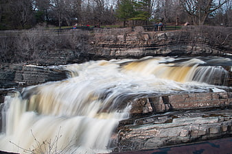 Long Exposure Waterfall Flowing Over Layered Rocks in Nature