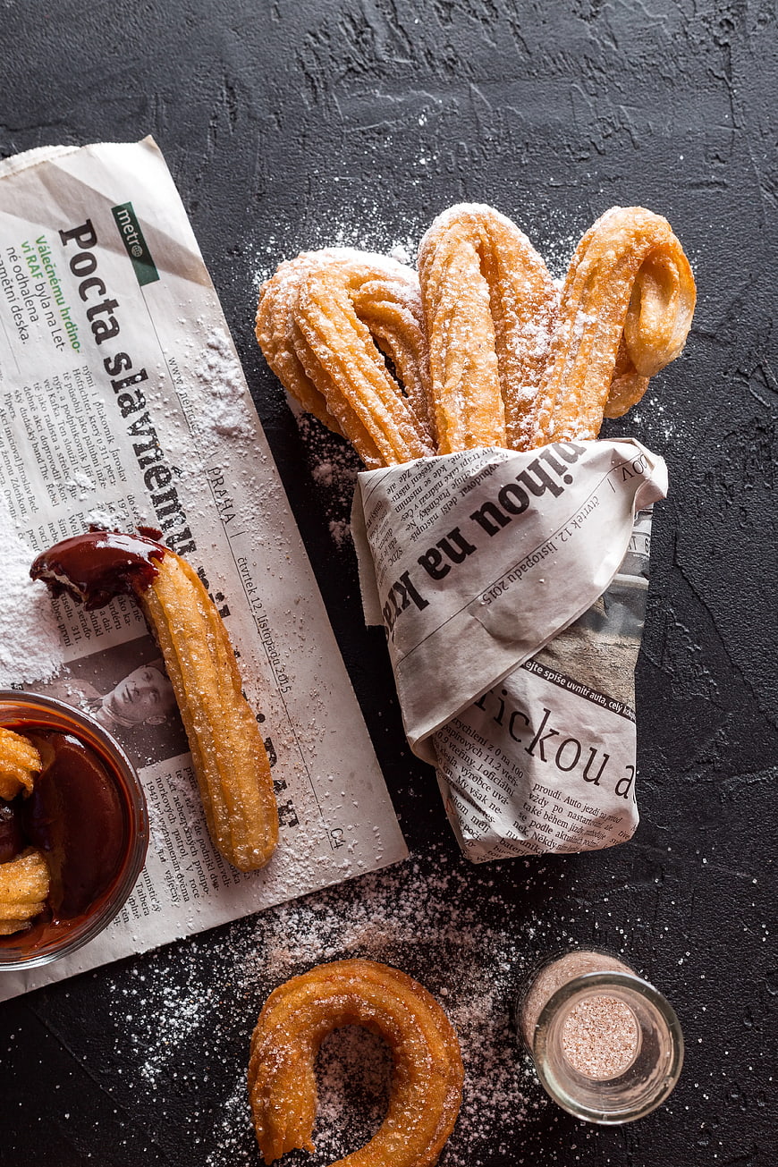 Traditional Churros with Chocolate Dip on Newspaper