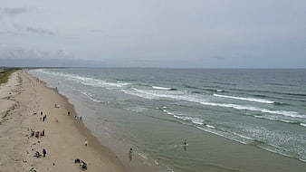 Aerial View of Sandy Beach with Waves and People
