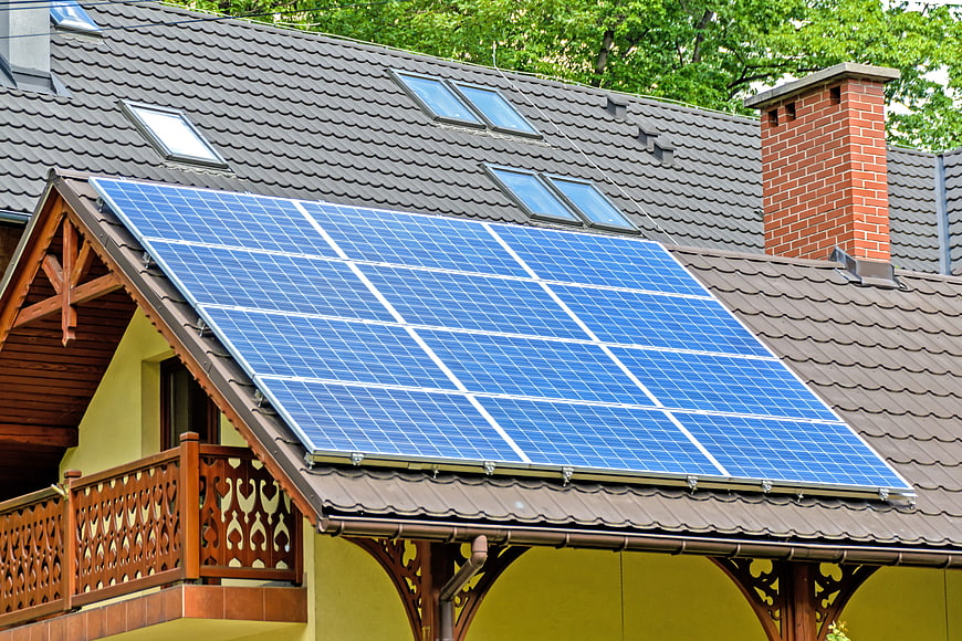 Solar panels on a residential roof with wooden balcony