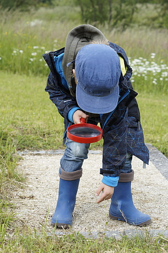 Child with Magnifying Glass Exploring Nature Outdoors