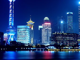 Shanghai skyline at night with Oriental Pearl Tower and river reflections