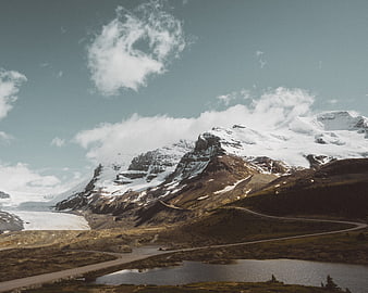 Winding Road Through Snowy Mountain Valley with Lake