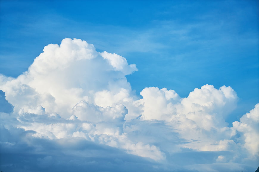 Majestic white cumulus clouds against a vibrant blue sky