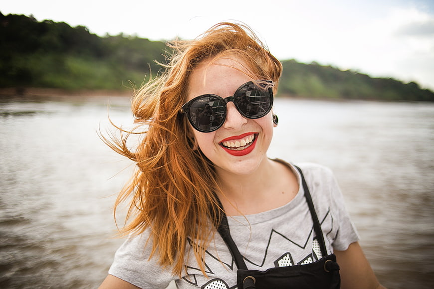 Happy Redhead Woman Smiling in Sunglasses on a Boat