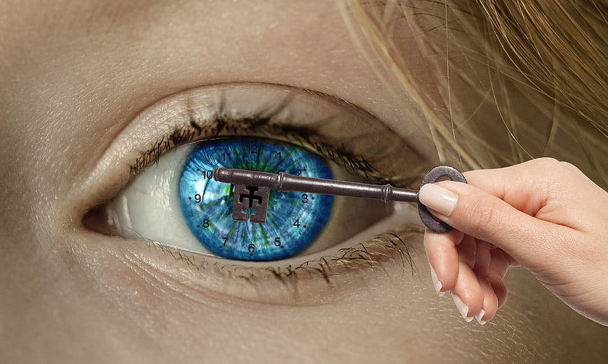 Conceptual Close-Up of Woman's Eye with Clock Face and Key
