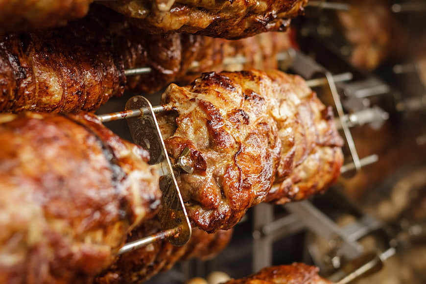 Close-up of roasted meat on rotisserie skewers