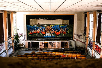 Abandoned Cinema Interior with Graffiti and Decaying Seats