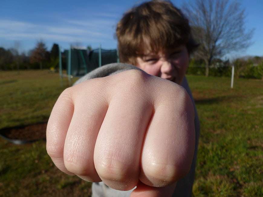 Boy Punching Fist Towards Camera Outdoors
