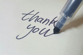 Handwritten thank you note with blue pen on white paper