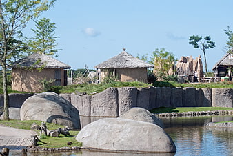 Traditional African Village Replica with Thatched Huts and Pond