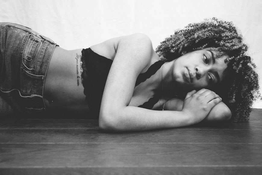 Black and white portrait of woman lying on floor