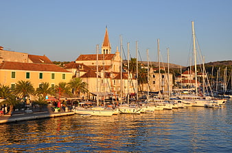 Sunset view of Hvar harbor with boats and church