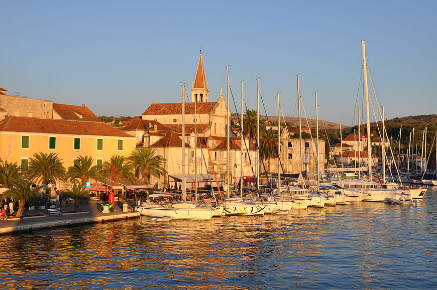 Sunset view of Hvar harbor with boats and church