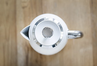 Overhead view of white teapot on wooden table