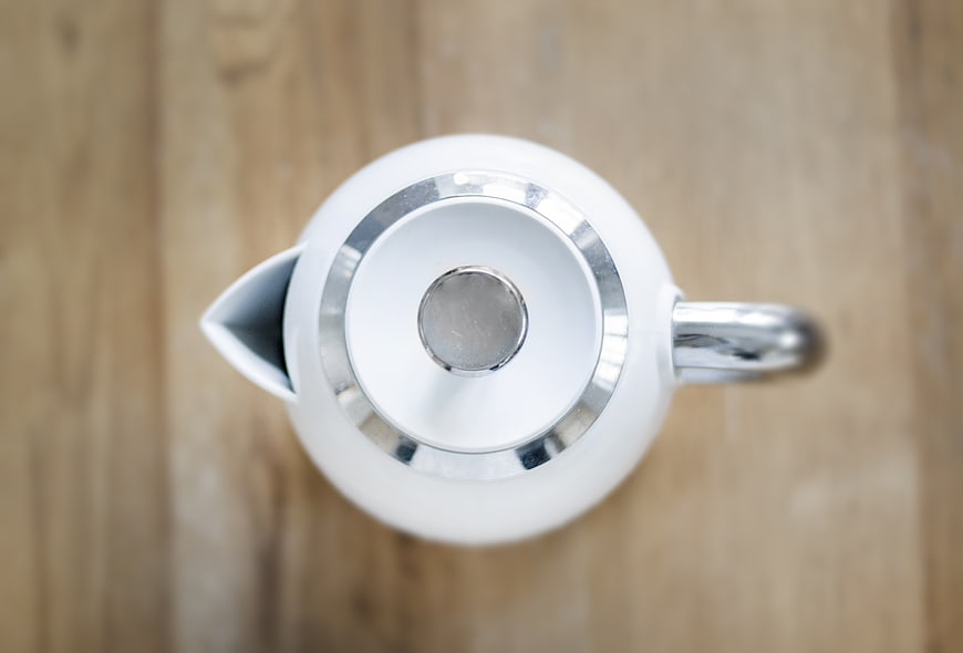 Overhead view of white teapot on wooden table