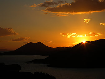 Golden Sunset Over Silhouetted Volcanic Islands and Sea