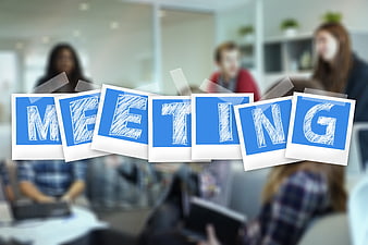 Meeting word on polaroids with blurred business team background