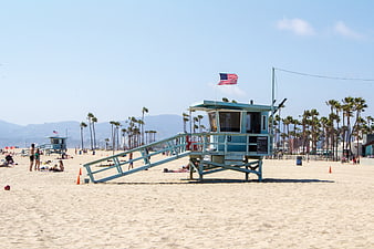 Blue Lifeguard Tower On Sunny Beach With Palm Trees And American Flag