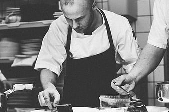 Chef Plating Food in Professional Kitchen Black and White