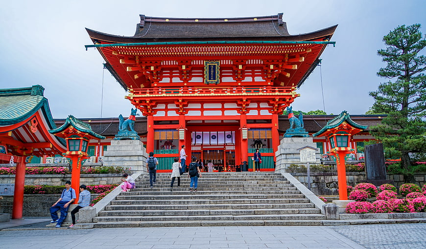 Traditional Japanese Shrine Gate with Red Architecture and Visitors
