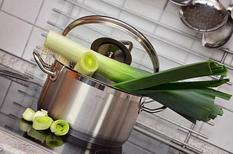 Fresh leeks in stainless steel cooking pot on kitchen counter