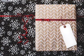 Christmas Gift Box with Blank Tag on Snowflake Background