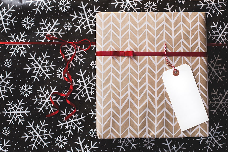 Christmas Gift Box with Blank Tag on Snowflake Background