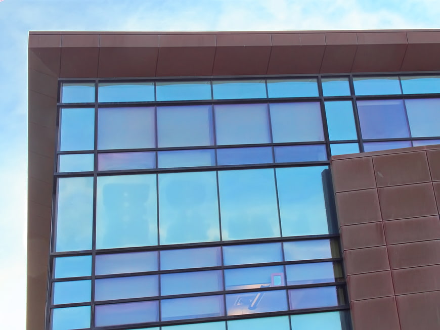 Modern building facade with blue glass windows and brown panels