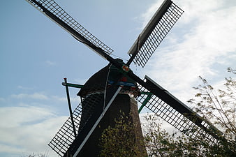 Low angle view of traditional Dutch windmill against blue sky