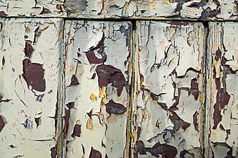 Close-up of peeling white paint on weathered wooden planks