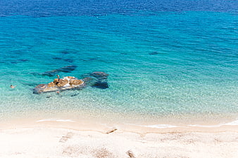 Aerial View of Turquoise Beach with Swimmers and Rocks