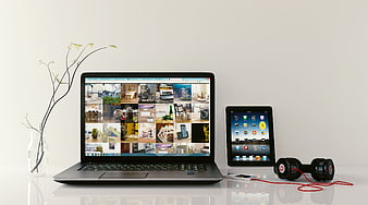Modern workspace with laptop, tablet, and headphones on white desk