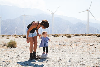 Mother and Toddler in Desert with Wind Turbines