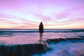 Woman Silhouette on Beach at Sunset with Pink Sky