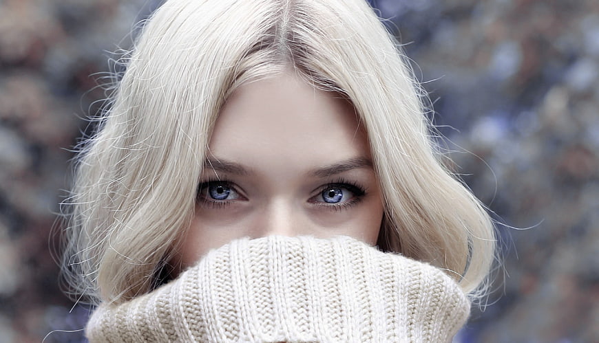 Close-up portrait of blonde woman with blue eyes in winter sweater
