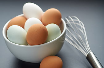 Fresh Multi-Colored Eggs in White Bowl with Whisk