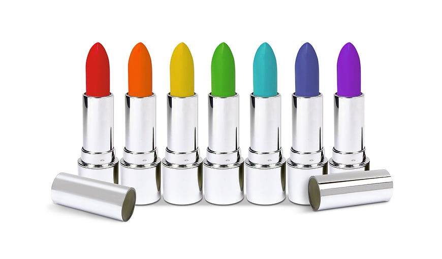 Rainbow colored lipsticks in silver tubes on white background
