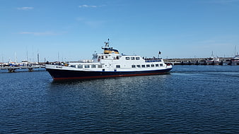 White and blue ferry boat named Binz sailing in harbor