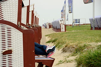 Relaxing legs in sneakers on a traditional German beach chair
