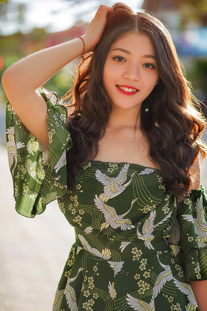 Smiling Asian Woman in Green Crane Pattern Dress