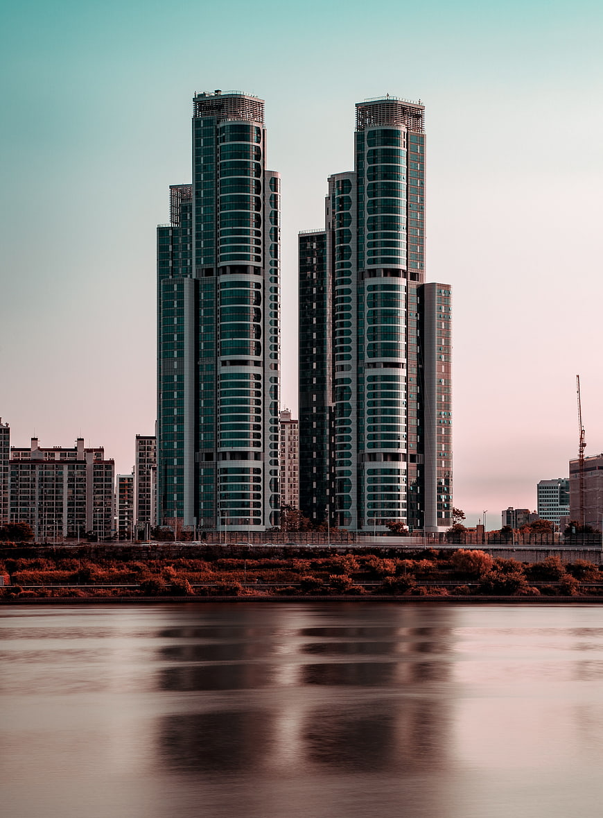 Twin High-Rise Towers Reflected in River at Dusk