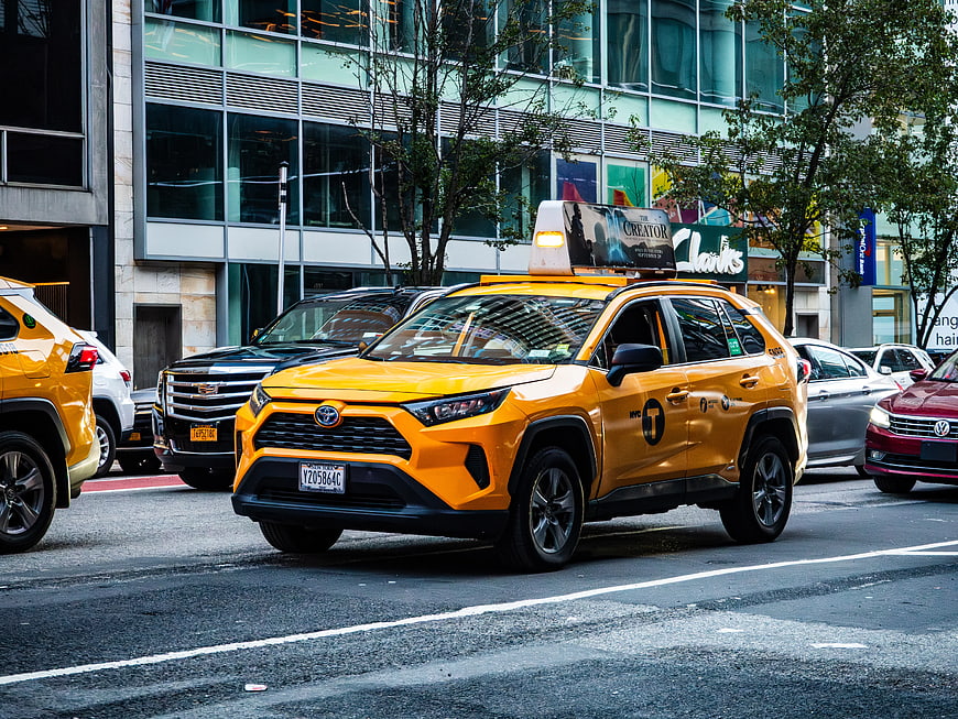 Yellow Toyota RAV4 Taxi in City Traffic